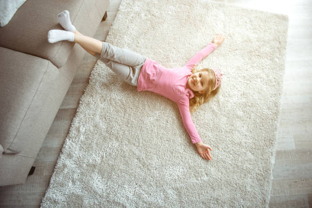 istock Happy small girl lying on floor near sofa 1138375526