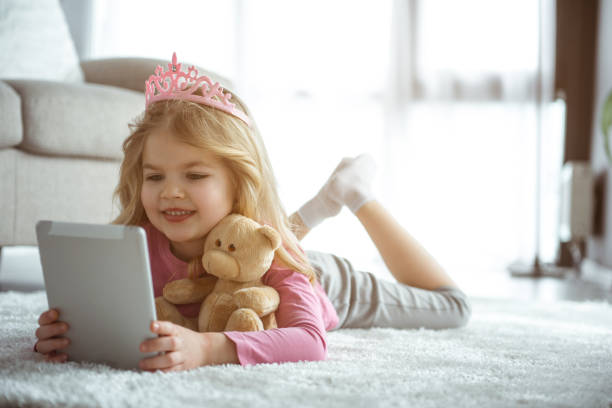 istock Joyful child entertaining with gadget at home 1138375532