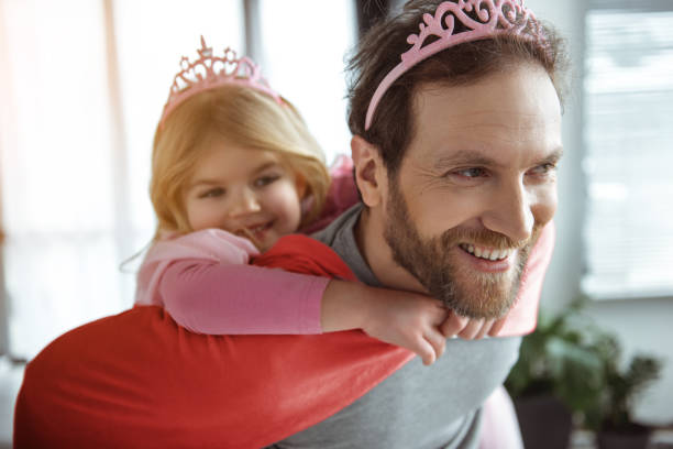 istock Glad father carrying girl on shoulders 1138375590