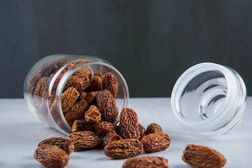 Scattered Dried Dates In Glass Jar
