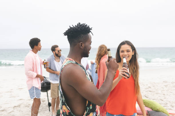 istock Group of friends enjoying on beach while having beer 1138376759