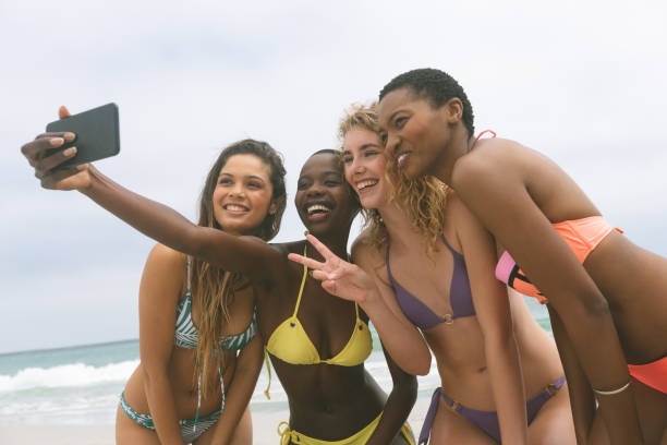 istock Women with bikini taking selfie on beach 1138376879