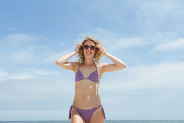 istock Woman standing at beach on sunny day 1138377812