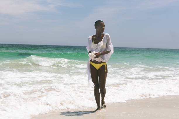 istock Woman relaxing and standing on beach 1138378104