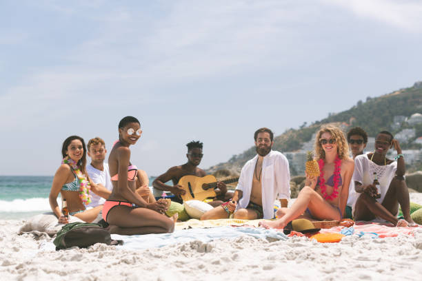 istock Group of friends relaxing and sitting on beach 1138379694