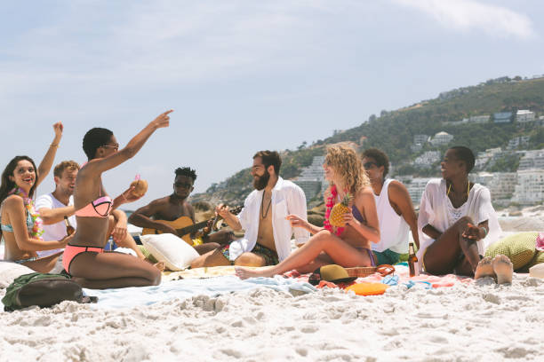 istock Group of friends relaxing and sitting on beach 1138379718