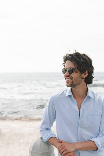 istock Caucasian man standing at beach on a sunny day 1138380970
