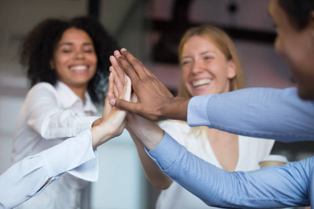 istock Close up diverse employees joining hand, giving high five 1138382775