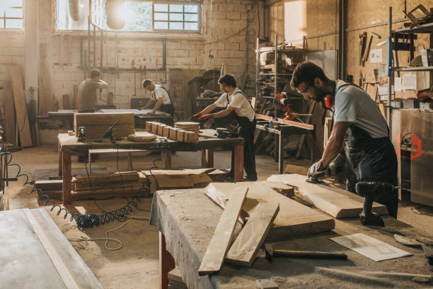 istock Group of manual workers making furniture at carpentry workshop. 1138382984