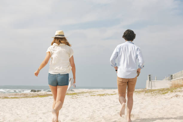 istock Caucasian couple running at beach on a sunny day 1138384147