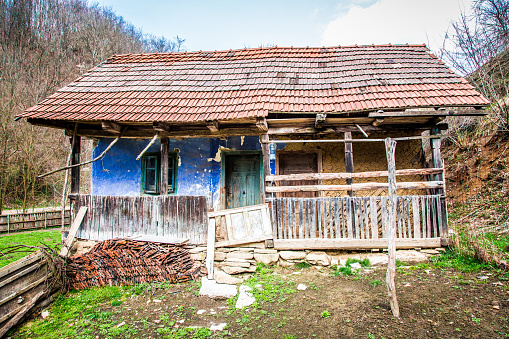 Wide angle color image depicting a derelict, abandoned house in an ancient, traditional village in Transylvania, Romania. Room for copy space.