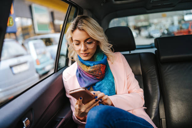 istock Woman with phone on the back car seat 1138384666