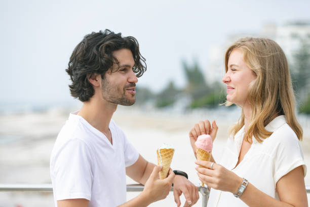 istock Caucasian couple standing at promenade while having ice cream cone 1138386074