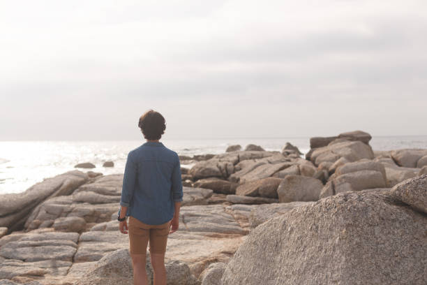 istock Caucasian man standing  at beach on a sunny day 1138386264