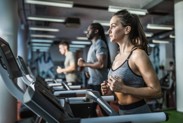 istock Young female athlete jogging on treadmill in a gym. 1138387623