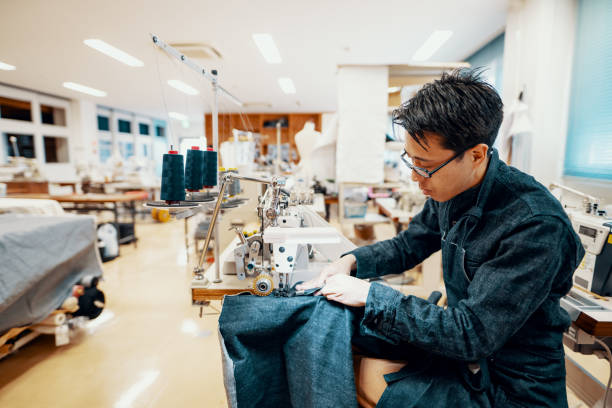 istock Mid adult man making denim jeans on a sewing machine at a textile studio 1138387984