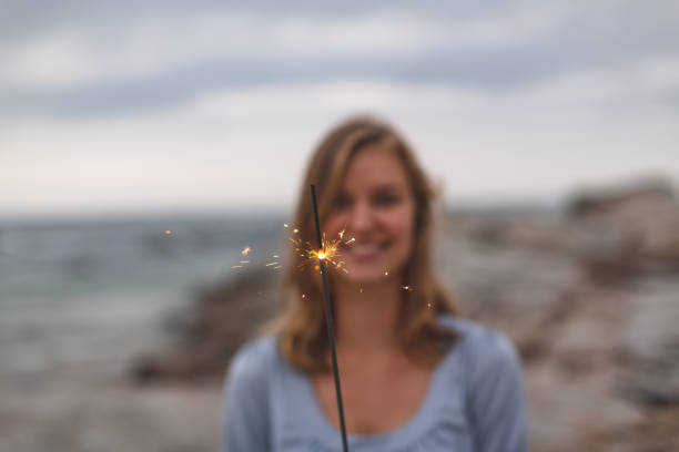 istock Caucasian woman standing with sparkle at beach 1138388101