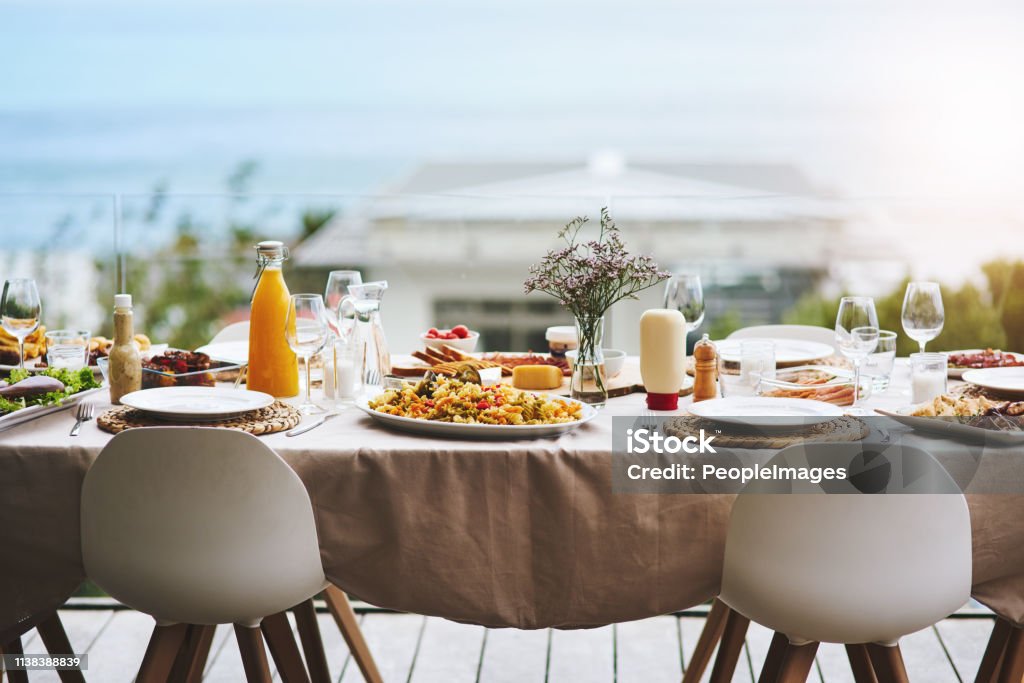 Only bring an empty stomach, we'll handle the rest Shot of a beautiful table setting outdoors Table Stock Photo