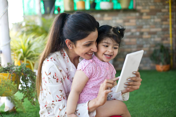 istock Happy mother and daughter using digital tablet at porch 1138388980