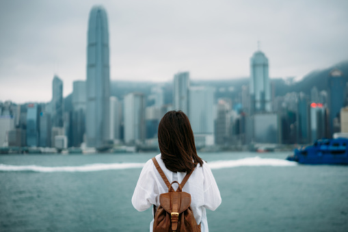Young woman traveler is looking cityscape view of Hong Kong China