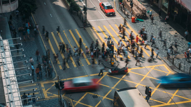 menschen und taxis, die einen stark befahrenen kreuzweg im stadtteil tsim sha tsui in hongkong, china, überqueren - store market china city street stock-fotos und bilder