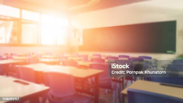 School Classroom In Blur Background Without Young Student Blurry View Of Elementary Class Room No Kid Or Teacher With Chairs And Tables In Campus Stock Photo - Download Image Now