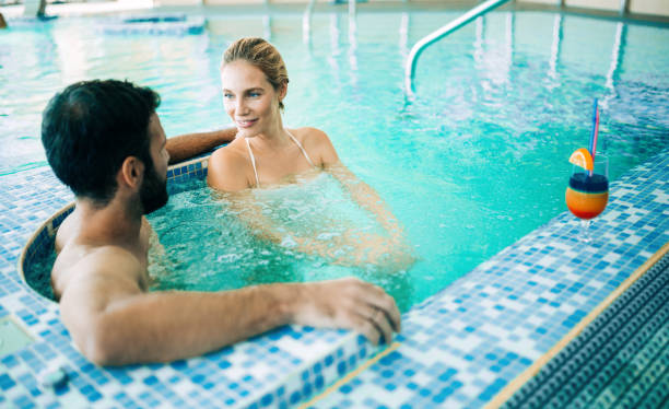 istock Happy attractive couple relaxing in swimming pool 1138392445