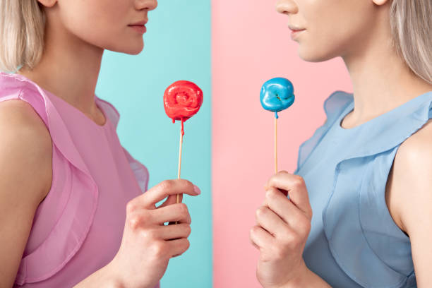 istock Serious women standing with lollipops 1138393518