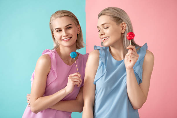 istock Happy sisters taking pleasure in eating candies 1138393575