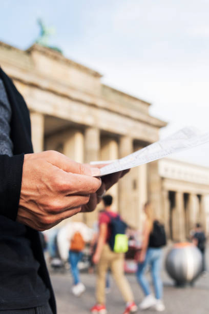 istock man checking a map at the Brandenburg Gate, Berlin 1138395388