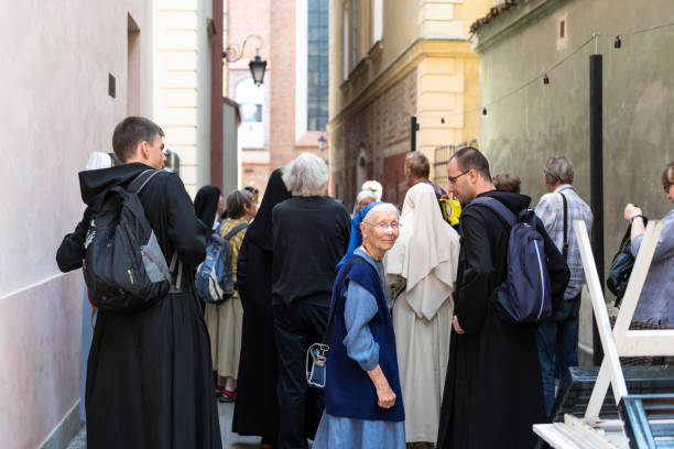 stare miasto z grupą zakonnych mniszek i księży na zabytkowej ulicy podczas słonecznego letniego dnia razem - nun praying clergy women zdjęcia i obrazy z banku zdjęć