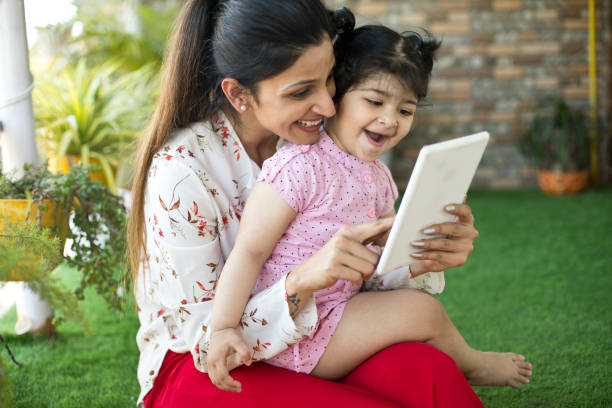 istock Happy mother and daughter using digital tablet at porch 1138398271
