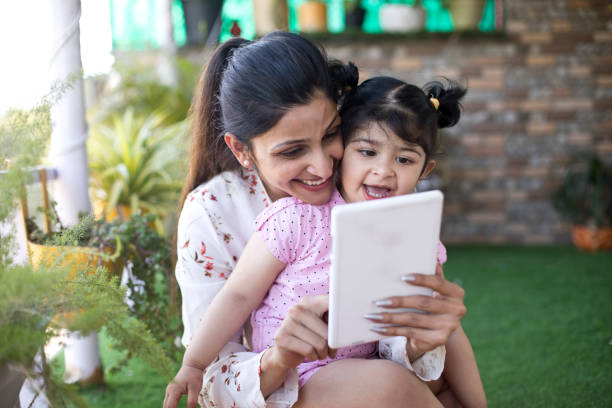 istock Happy mother and daughter using digital tablet at porch 1138398319