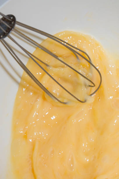 istock Whipping chicken eggs with a metal whisk in a mixing bowl 1138398372