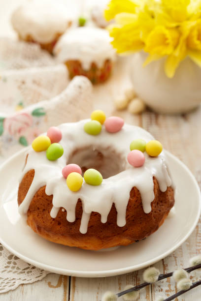 istock Easter yeast cake (Babka) covered with icing and decorated with marzipan eggs on a white plate on a wooden table. 1138400538