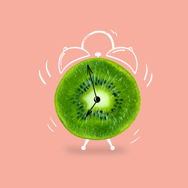 Creative idea layout fresh kiwi slice alarm clock on pastel pink background