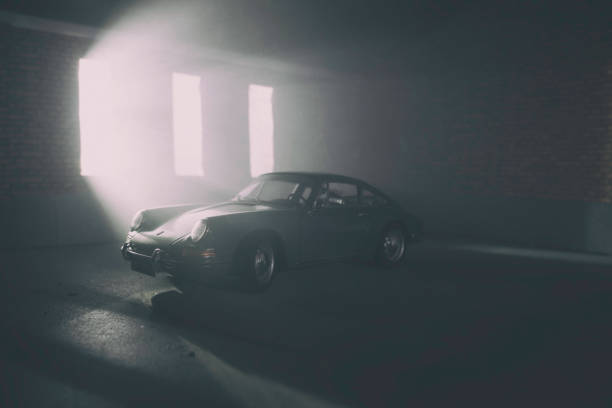 Beaconsfield, UK - March 25, 2019: A scale model of a 1964 Porsche 911 in an old garage setting. The model Porsche is sitting in an atmospherically-lit industrial garage environment. The garage environment/model is made out of fibre-board, and was photographed in my actual garage here in Beaconsfield. There is no one in the photograph.