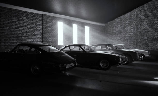 Garage Of Dream Car (Models) Beaconsfield, UK - March 25, 2019: A dream garage of collector's cars (in scale model form), featuring a 1964 Porsche 911, a 1963 Ferrari 250 GT Berlinetta Lusso, an Aston Martin DB5, and a Volvo 1800s. Sunlight streams through the windows of this abandoned garage illuminating the cars within.

The model cars are seen sitting in an atmospherically-lit industrial garage environment. The garage environment/model is made out of fibre-board, and was photographed in my actual garage here in Beaconsfield. There is no one in the photograph. volvo photos stock pictures, royalty-free photos & images