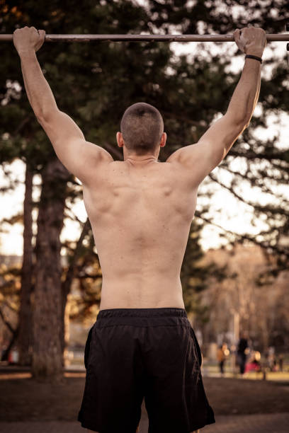 istock Handsome Young Athlete Doing Chin-ups on Horizontal Bar 1138412260