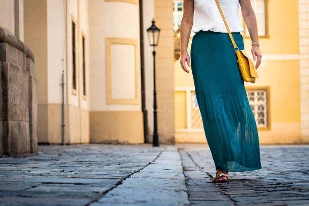 Woman dressed in green pleated skirt is walking at old town. Stylish and fashion concept skirt stock pictures, royalty-free photos & images