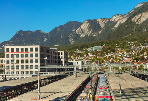 Chur, Switzerland - September 27, 2018: railway station and buildings of the the city of Chur, summits of the Alps in the background. The city of Chur is the capital of the Swiss canton of Graubunden (French: Grisons).