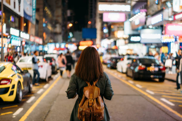 Young woman traveler traveling into Mongkok street market at night in Hong Kong China Young woman traveler traveling into Mongkok street market at night in Hong Kong China mong kok stock pictures, royalty-free photos & images