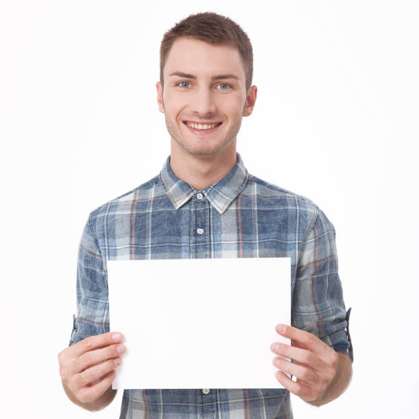 istock Young man holding white blank billboard close-up on white background. 1138415507
