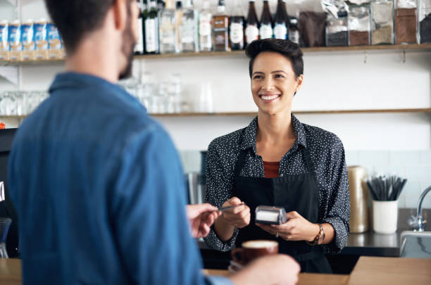 Let me swipe your card Shot of a barista serving a customer in a coffee shop point of sale stock pictures, royalty-free photos & images