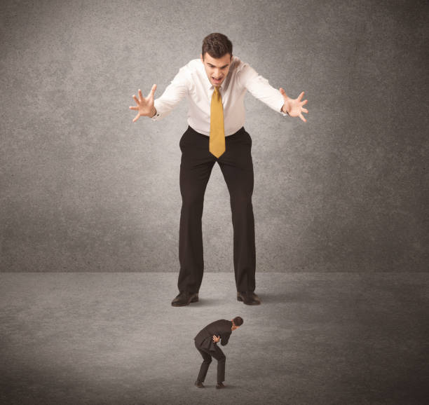 istock Big business man looking at small worker 1138416475
