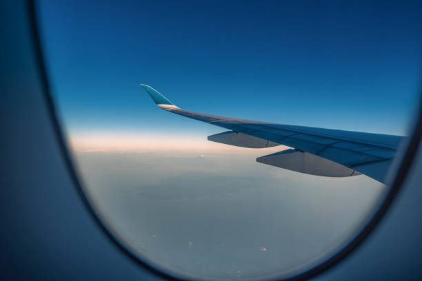 istock Silhouette wing of an airplane at sunrise view through the window. 1138417367