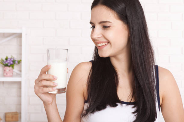 istock Happy young woman drinking milk 1138419239