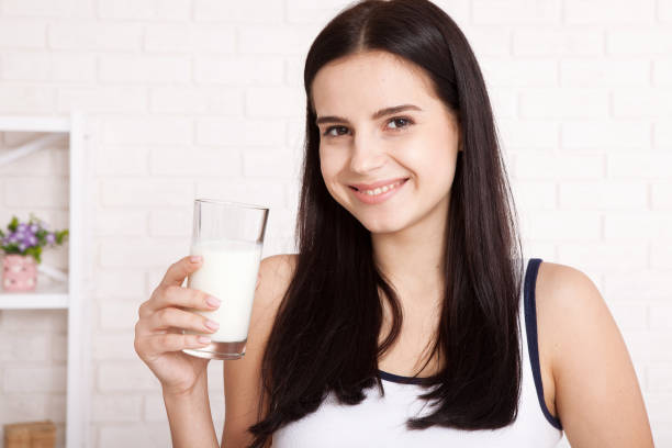 istock Happy young woman drinking milk 1138419246