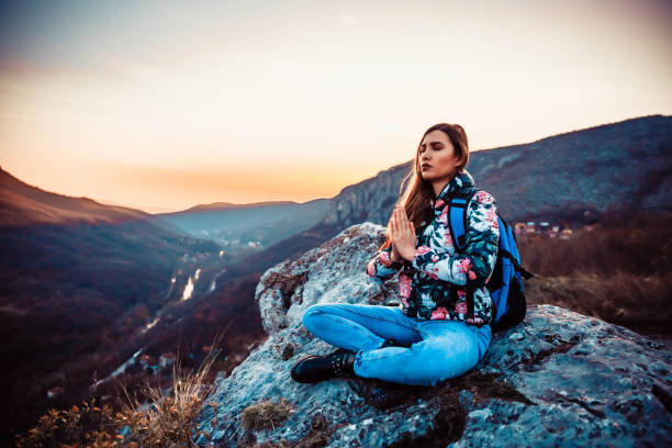 istock Woman doing yoga on mountain pick 1138419420