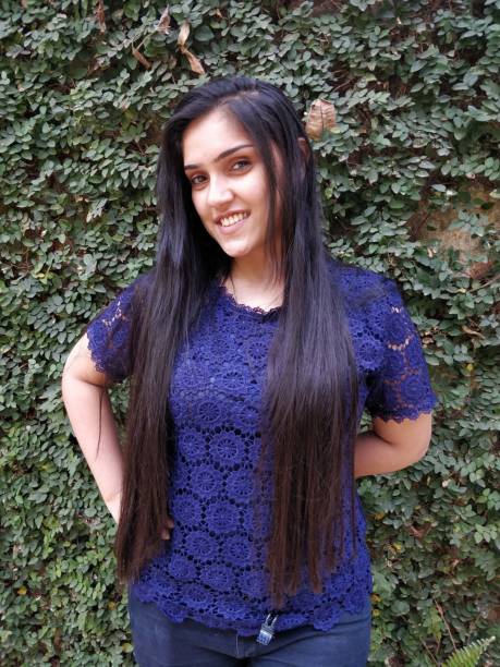 istock Beautiful young woman posing against wall 1138420142